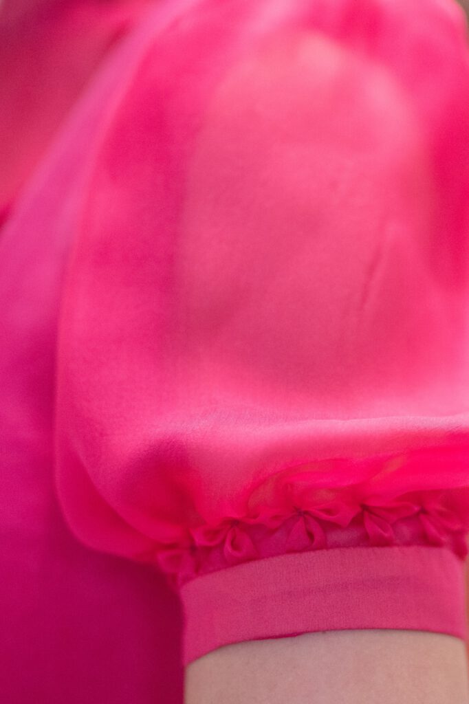 Blusenärmel von pinker Dirndlbluse aus Seidenchiffon mit Blütensmok